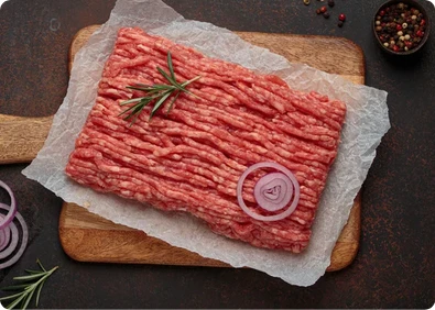 Minced beef on paper and a wooden board