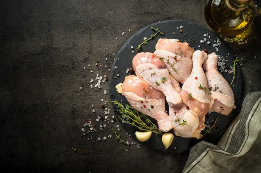 Raw chicken breast and diced chicken on a board