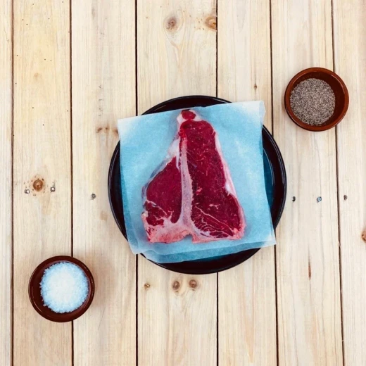 Raw steak with peppercorns and rosemary